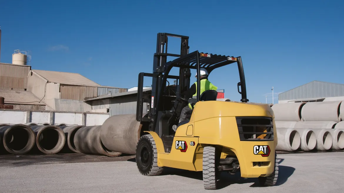 Cat diesel counterbalance forklift handling concrete pipes in a yard